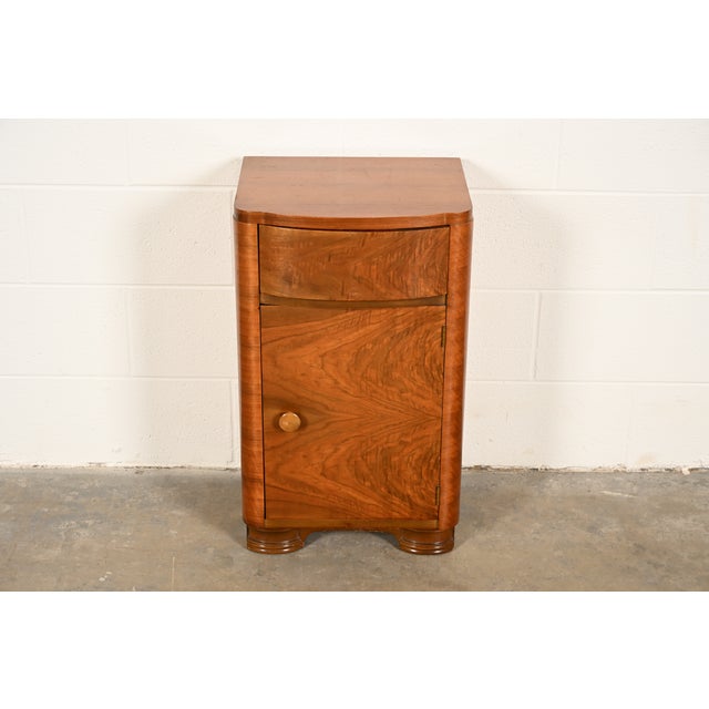 A gorgeous antique Art Deco period burled walnut nightstand In the manner of Donald Deskey By Joerns Bros. Furniture Co....