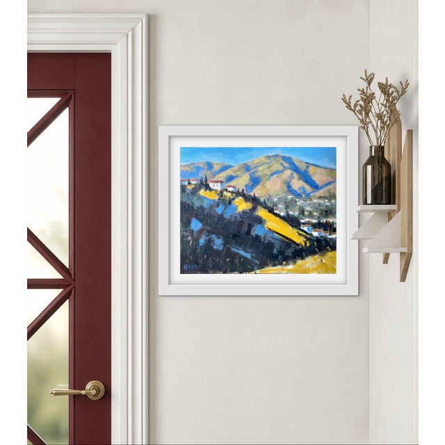 Golden Hillside captures the warm morning light spilling across a quiet hillside village beneath distant blue shadowed...