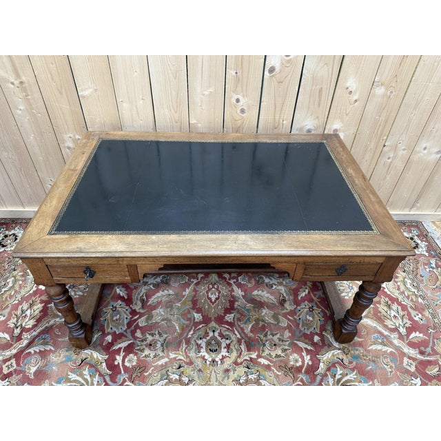 Louis XIII style flat desk in solid walnut and black leather with gilt tooling, opening to reveal two drawers. An elegant...
