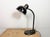 This black Bauhaus industrial desk lamp with two adjustable joints was made in Germany during the 1930s. It features black...