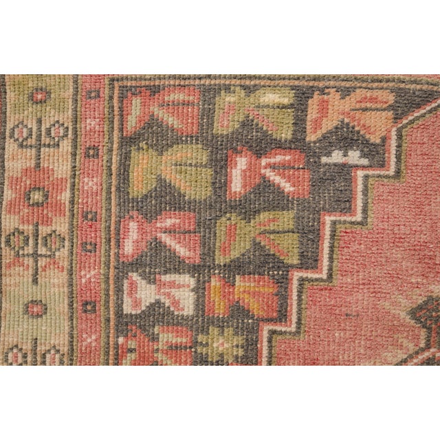 This is a vintage Turkish Oushak rug from the Mid 20th Century. The piece was hand-knotted.