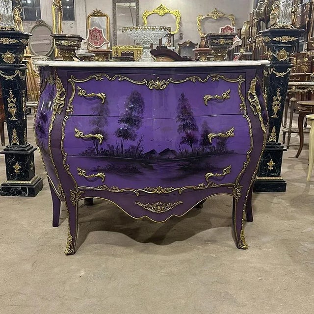 In love with the gold details. Art stands out in every corner of this purple commode, it has 3 drawers decorated with gold...
