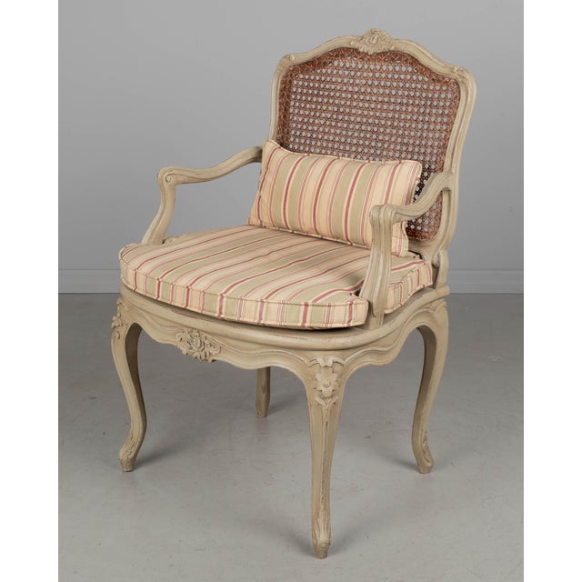 A Louis XV style French fauteuil, or arm chair, made of solid carved beech wood with verdigris painted finish and hand...
