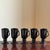 Offering a handsome set of five vintage Hall China black glazed pedestal mugs. These distinctive mugs feature a sleek...
