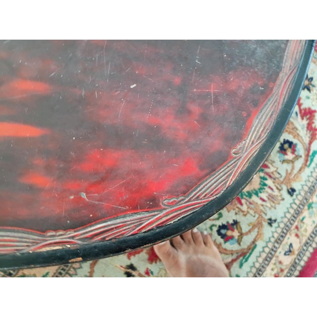 Asian, possibly Japanese, low table finished in red and black with inlaid that looks to be mother of pearl. It's very low...