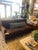 A rich brown velvet sofa with a deep, moody tone and plush, relaxed cushions. Clean arms and tapered wood legs set on...