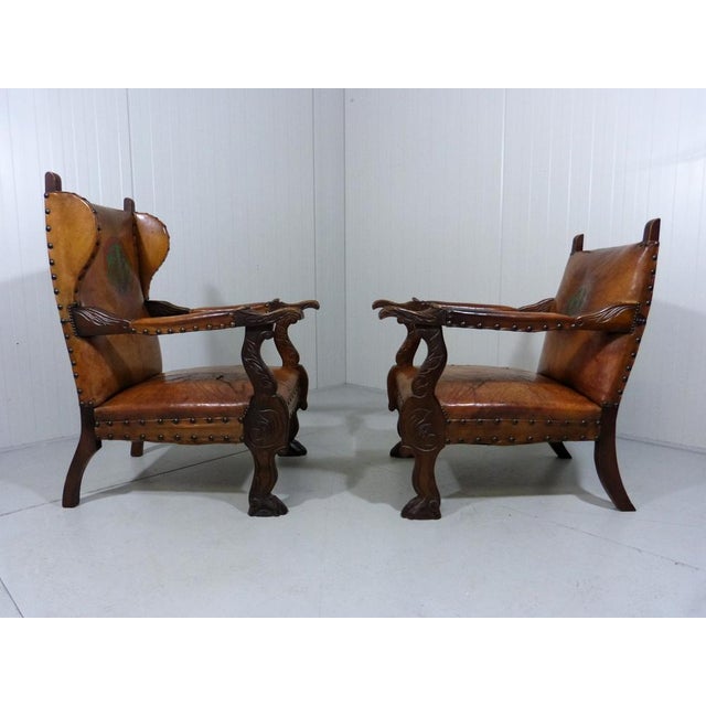 Beautiful pair of arm chairs in castle style. 1 Wingback chair and 1 arm chair . Wooden frame with rich wood engraving,...