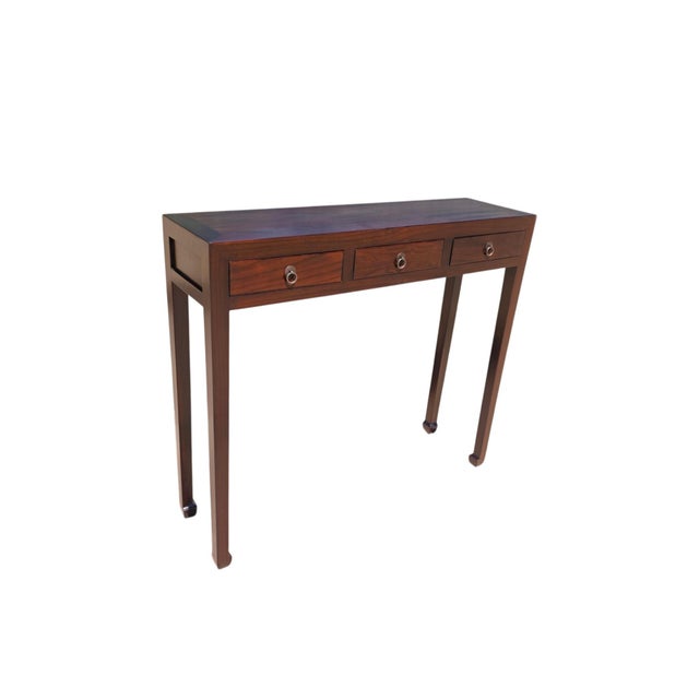 This vintage wooden console table features three side-by-side drawers across the front, each detailed with a traditional...
