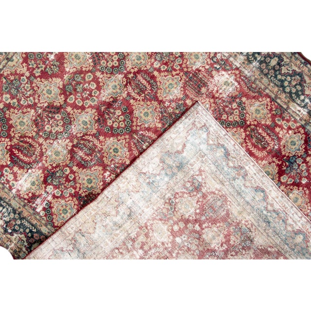 Beautiful vintage Persian distressed hand-knotted wool rug with a red field. This piece has multicolor accents in a floral...