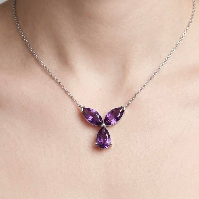 Gracefully designed with a floral-inspired silhouette, this elegant pendant features a stunning arrangement of Amethyst...
