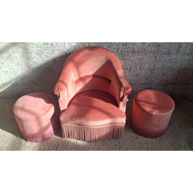A napoleon iii salon suite comprising a toadstool armchair and two matching cylindrical poufs. The armchair features a...