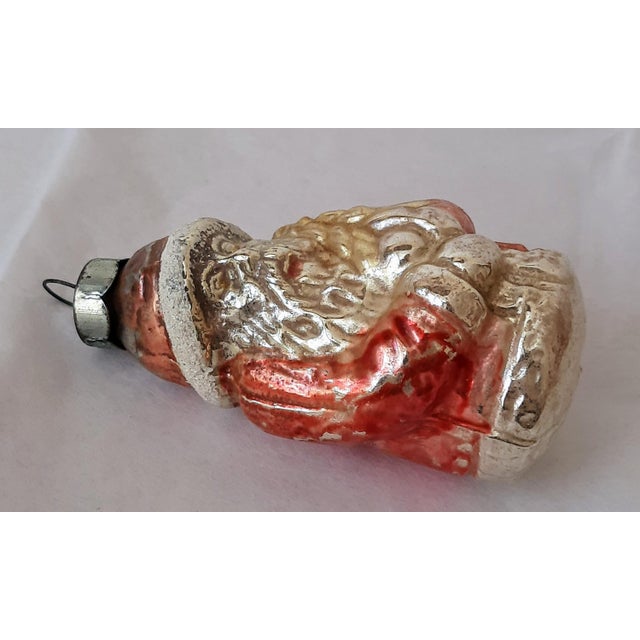 Old mercury glass St. Nicholas Santa Claus Christmas ornament. He is dressed in a traditional long red robe with a long...