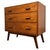 A handsome vintage 20th-century English chest of drawers, finely crafted from golden oak and distinguished by its three...