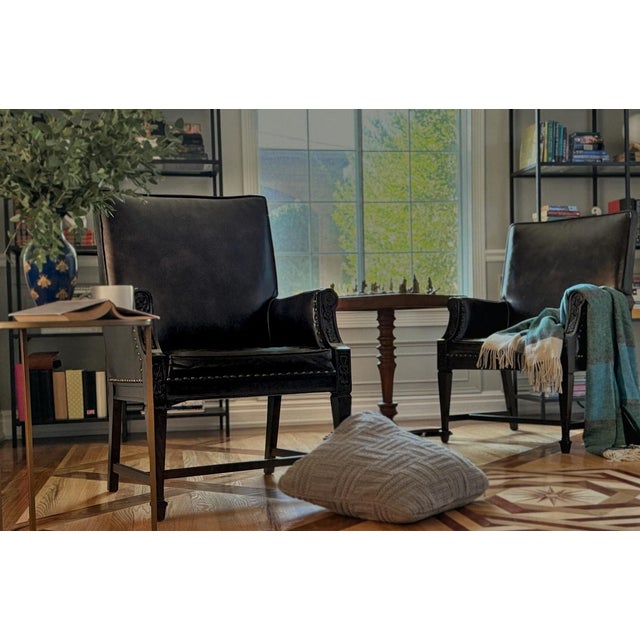 A distinguished pair of carved leather armchairs by Romweber, presented in deep espresso brown toned leather with hand-...