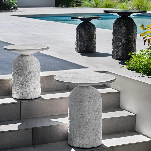 This fossilized stone side table pairs a carved base with a dial-design round top, bringing organic texture beside an...
