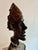 Modern bronze sculpture depicting an elongated male head with a dark brown patina. This bronze bust is a three-dimensional...