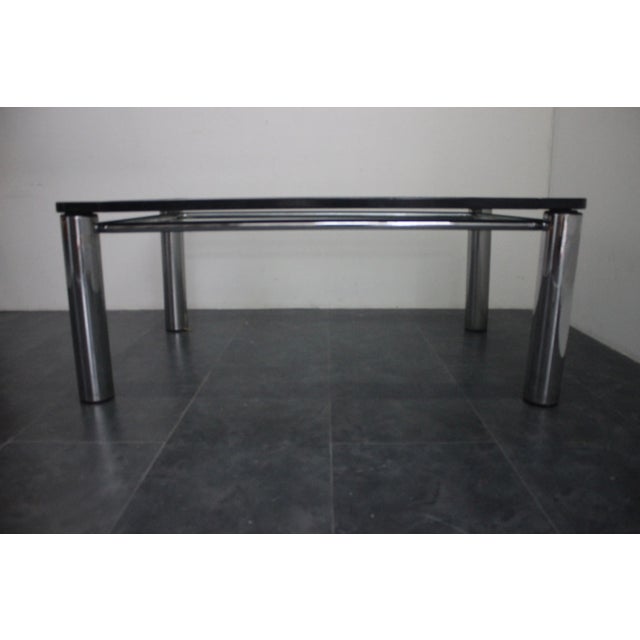 Vintage steel table with crystal top edged in black lacquered wood Italy 1970. This piece is attributed to the mentioned...