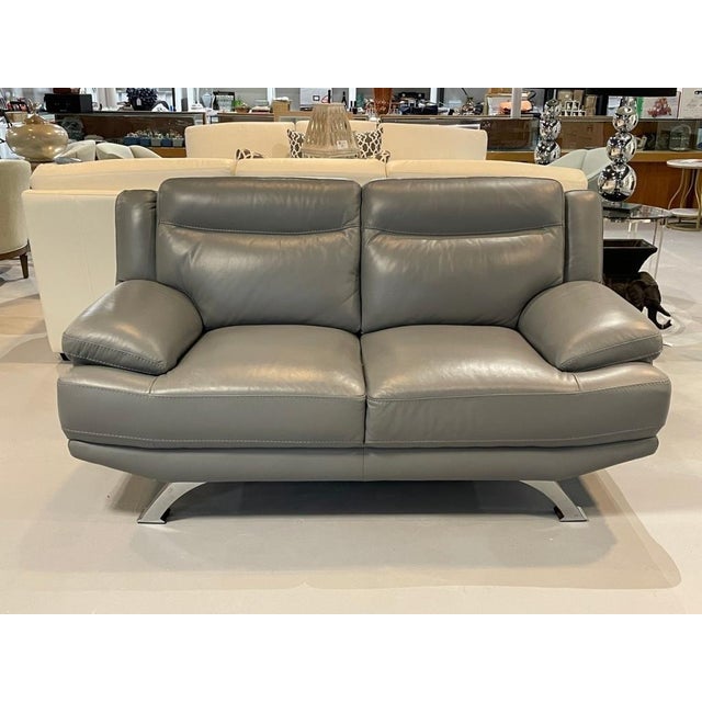 MODERN GRAY LEATHER LOVESEAT WITH METAL BASE -Matching gray leather loveseat featuring plush cushioning, wide arms, and a...