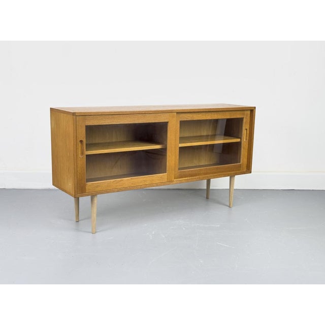 A high-quality display cabinet crafted from oiled oak with a warm, natural look. The two sliding doors feature solid wood...