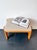 Add a touch of vintage charm to your interior with this authentic Mid-Century wooden footstool / Ottoman. Dating from the...