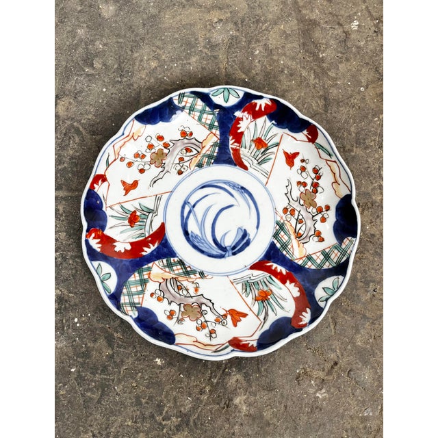 Antique Japanese Imari plate. Blue and white blades of grass center with red blue and white panel details.