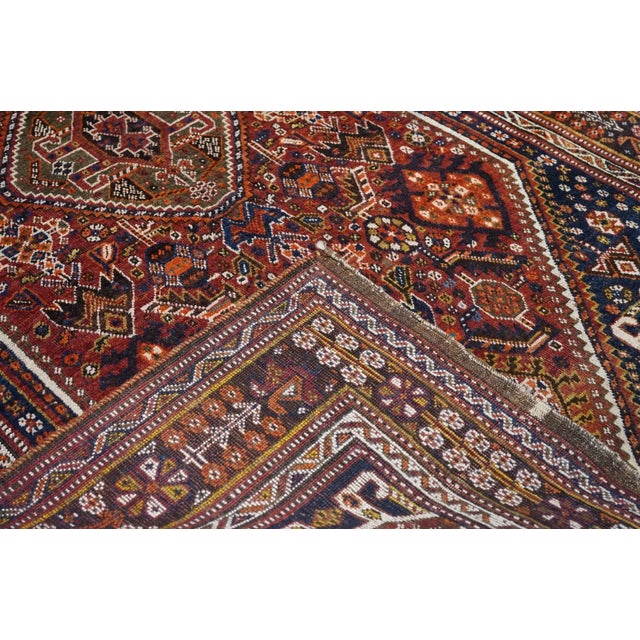 This moderately woven southwest Persian nomadic large scatter presents a very dark blue field with stylized "Qashghai gul"...