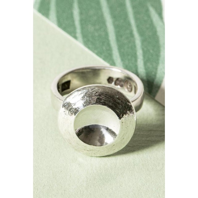 Silver ring by Sven-Erik Högberg, adorned with a silver disc that is concave in the middle, creating a play with light....