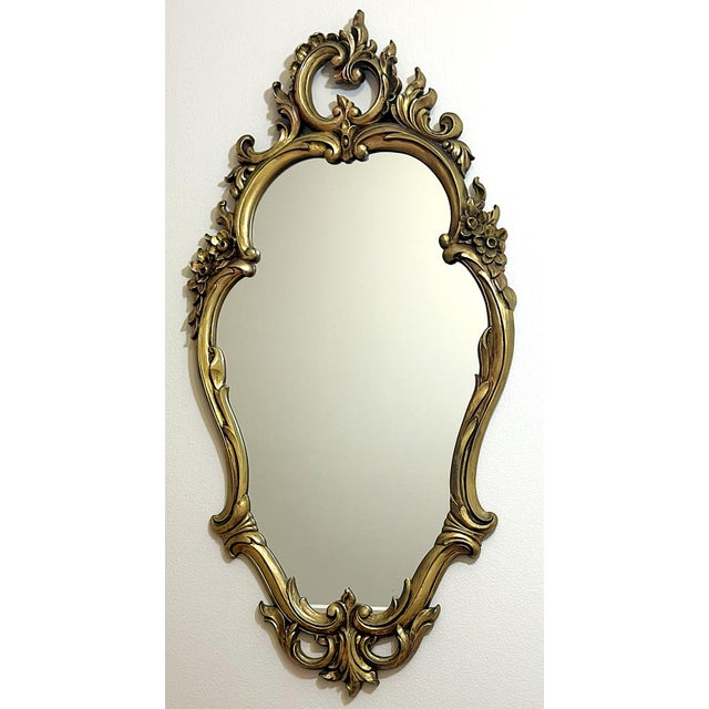 Fantastic large Hollywood Regency style wall mirror by Syroco from the mid 20th century. It has an oval shape with ornate...