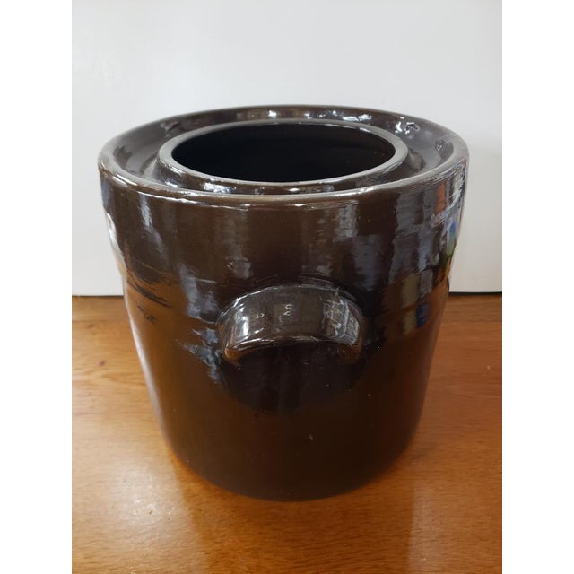 This is a Early 20th Century American Brown Glazed Stoneware Double Handled Crock. It measures 12" high, 15 1/2" wide...