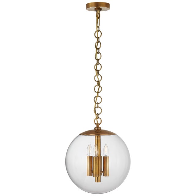 Turenne Medium Globe Pendant in Hand-Rubbed Antique Brass with Clear Glass Designer: AERIN Canopy: 5" Round Mounting:...