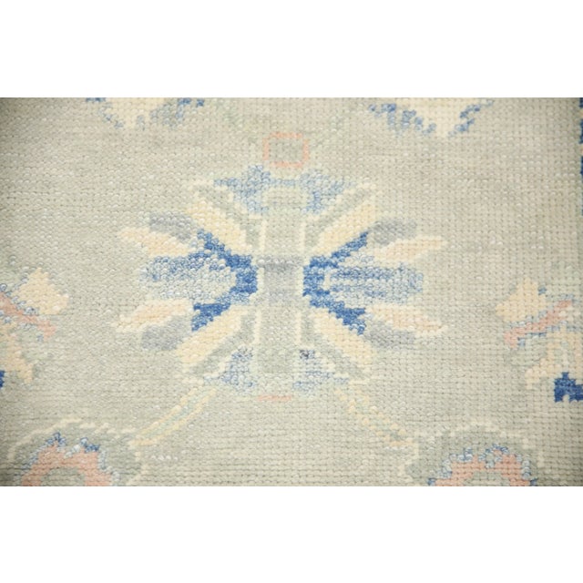 This modern Turkish Oushak rug is a stunning piece of art that has been handwoven using traditional techniques by skilled...