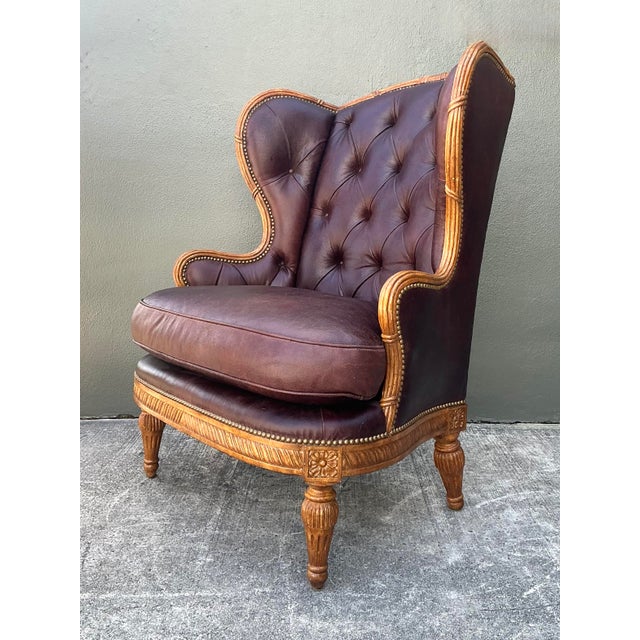This exceptional vintage wingback chair is a distinguished marriage of French Provincial elegance and classic library...