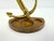 A vintage brass anchor mounted atop a heavy cast iron base, creating a distinctive nautical desk accessory with timeless...