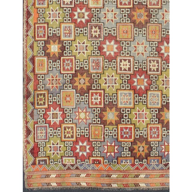 Measures: 6'2 x 9'4. Featuring tribal shapes of stars and boxes with a spotted and speckled assortment of geometric...