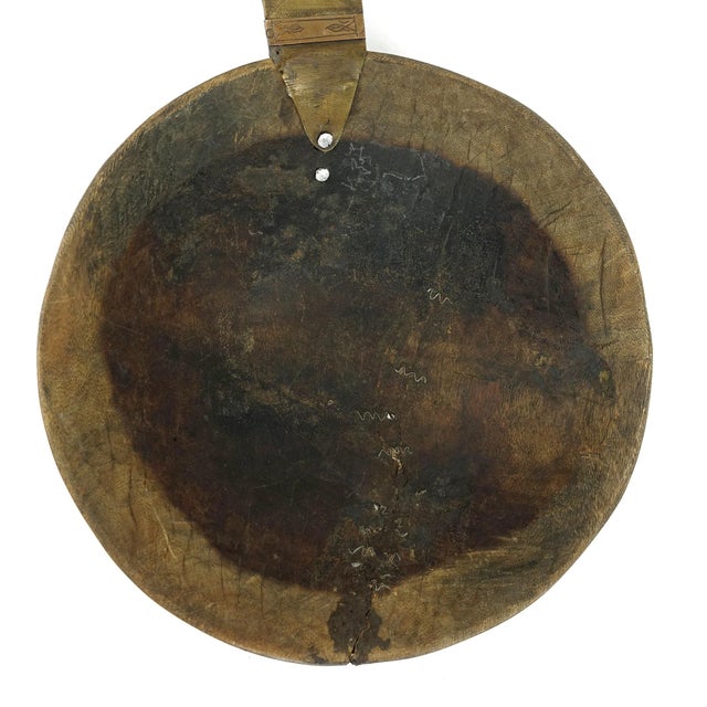 A large spoon or scoop made out of wood carved with a large bowl and a long handle with aluminum designs. This spoon is...