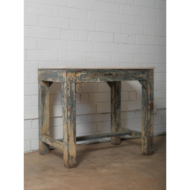 This console table combines a solid white marble top with a heavily worn wooden base showing layers of original blue and...