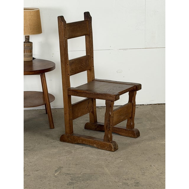 Set of six Dutch Brutalist dining chairs in solid oak from the mid-20th century. Their tall ladder backs, broad plank...