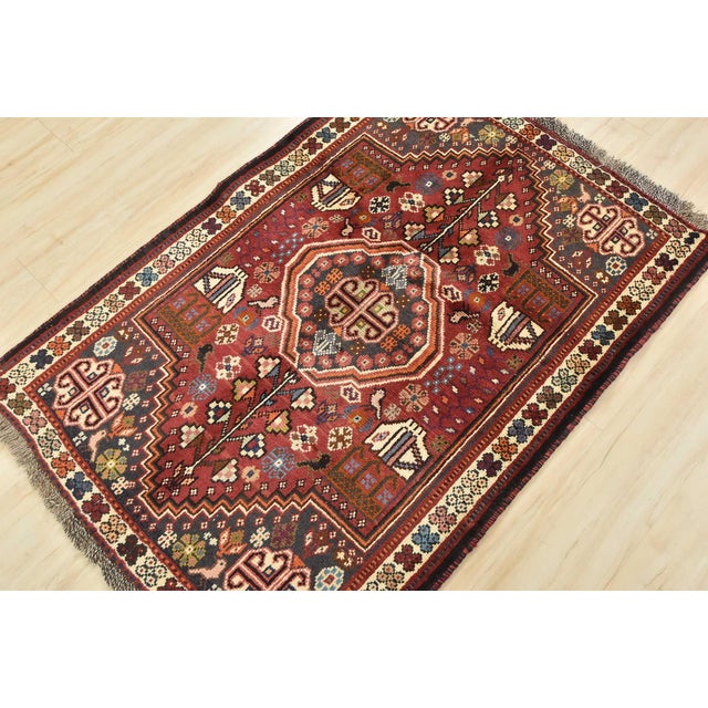 An authentic vintage tribal Shiraz rug hand-knotted with fine wool and natural dyes. This nomadic oriental rug features a...