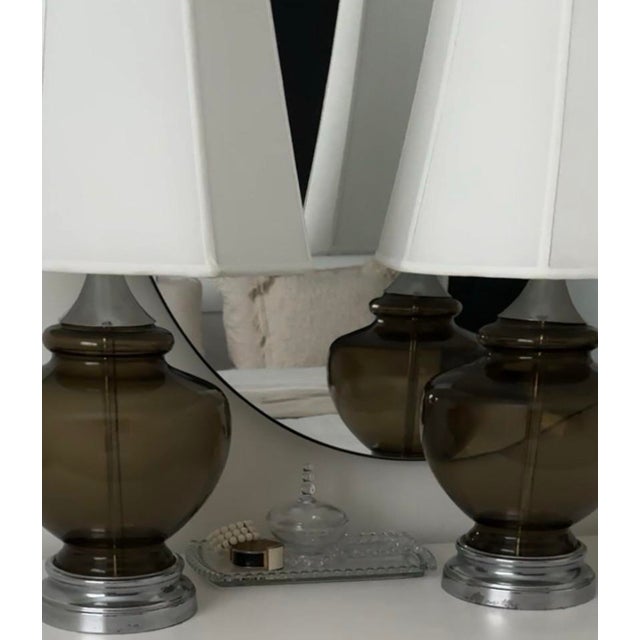 A sculptural pair of mid-century modern table lamps featuring generously scaled smoke-olive glass bodies with softly...