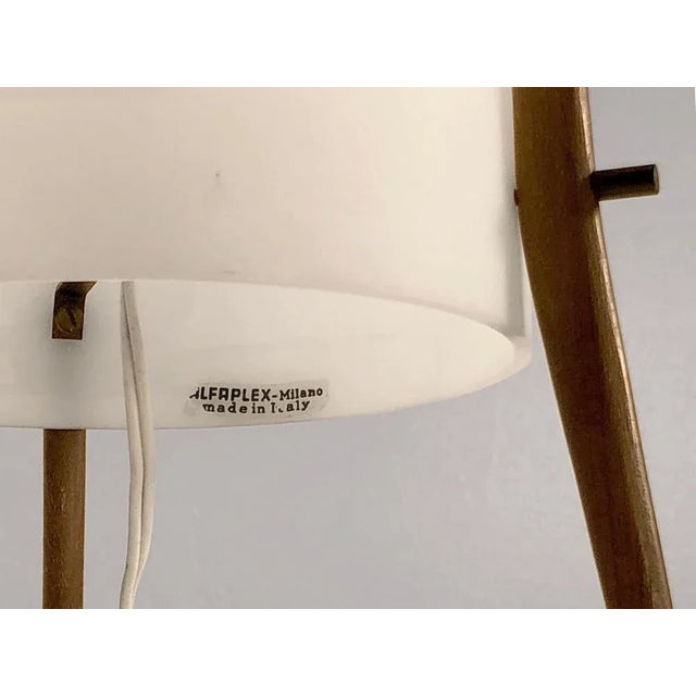 A small table lamp or Tripod, modernist, space-aged, fifties, white perspex cylinder diffusing satin mounted on 3 elegant...