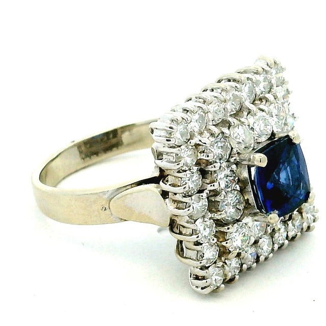 A classic vintage sapphire and diamond ring with a beautifully balanced, structured design. At the center sits a deep blue...