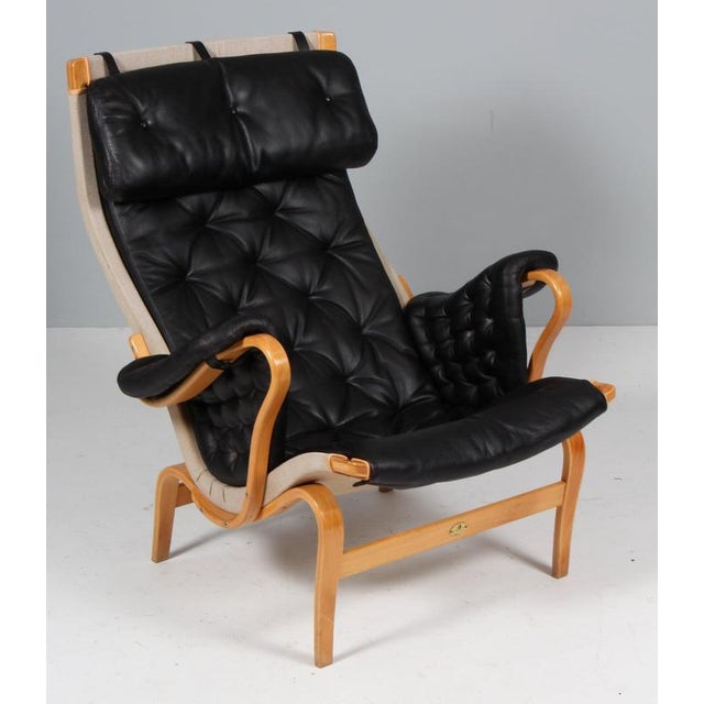 Bruno Mathsson Pernilla lounge chair with patinated leather. Frame in beech. Made by DUX. 25 years annivesary model This...