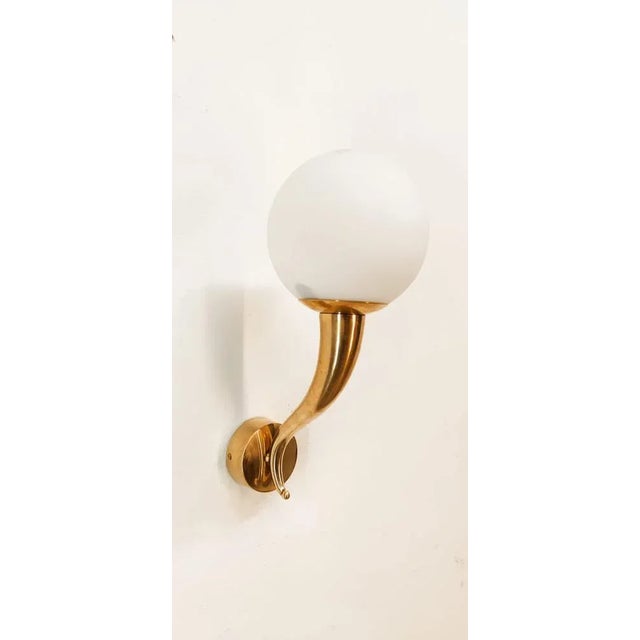 Brass Wall Light with White Sphere, in Very Good conditions. Designed 1970 to 1979 Up to 250V (Europe/UK Standard).The...