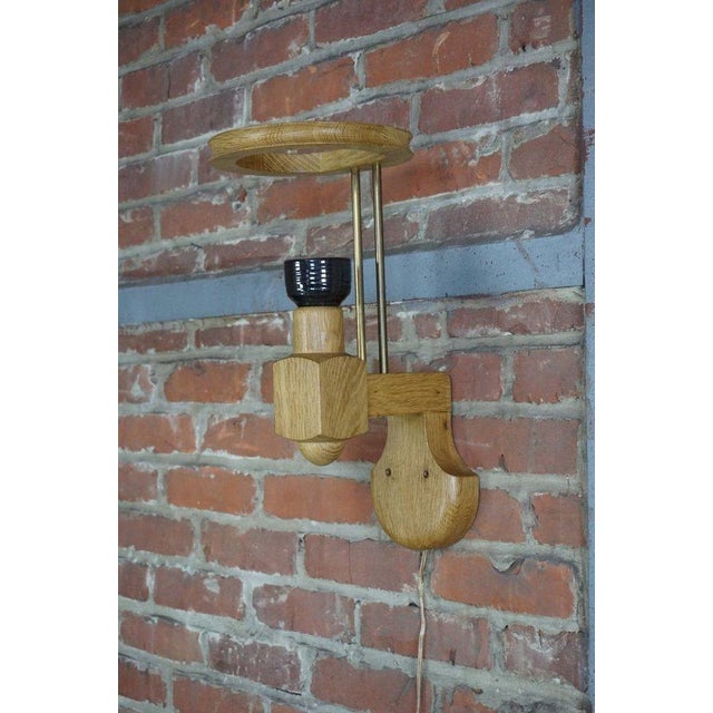 This solid oak wall light, with a Boleslaw Danikowski ceramic socket and signature dowels from the famous duo Guillerme...