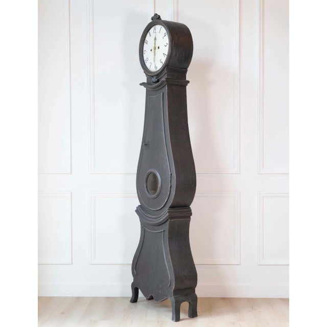 A striking 19th-century Swedish Mora clock, distinguished by its elegant elongated silhouette and dramatic deep charcoal...