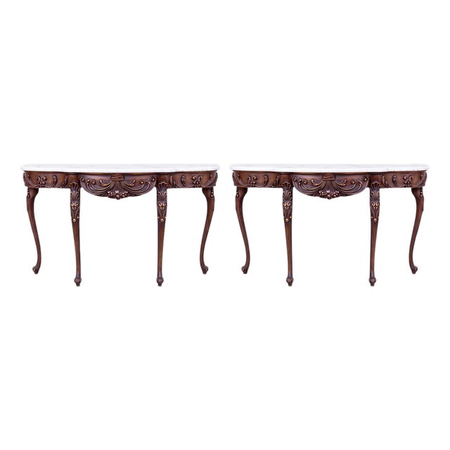 This is a pair of 1979s/80s Italian French Louis XV style carved mahogany and gilt demilune console tables with white...