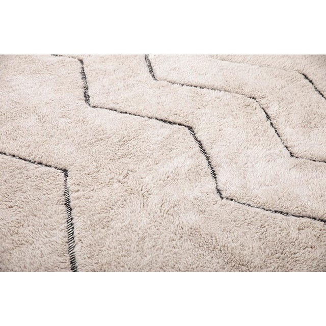 Elegant hand-knotted wool rug in Light Taupe, featuring zigzag patterns in Midnight Black. The bold yet minimalist design...