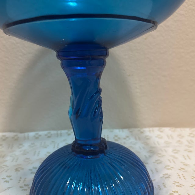 Elegant and eye-catching, this vintage blue glass compote features a distinctive stem in the form of a lady’s hand,...