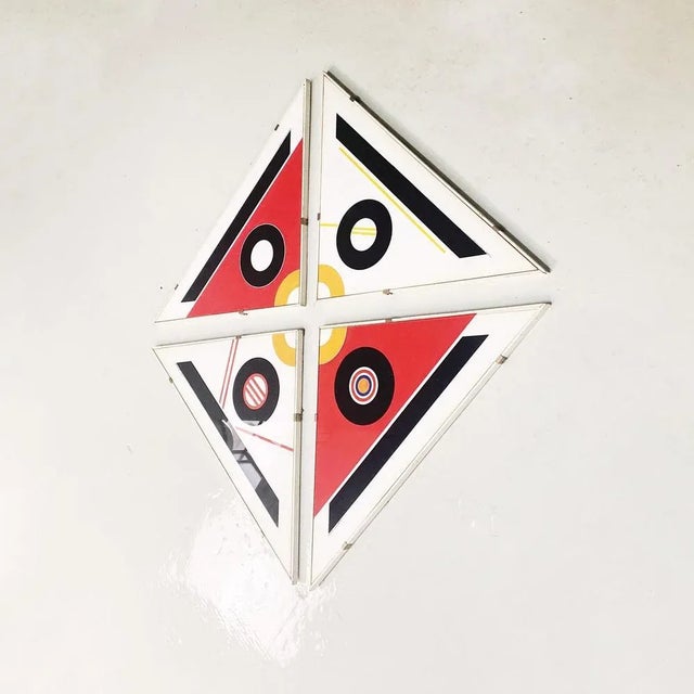 Set of four triangular-shaped pictures with prints depicting colored circles and geometric figures. The frames are...