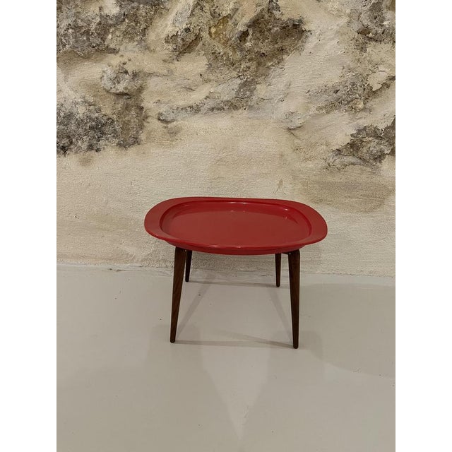 Red plastic tray, 4-legged wooden stand This piece is attributed to the mentioned designer/maker. It has no attribution...